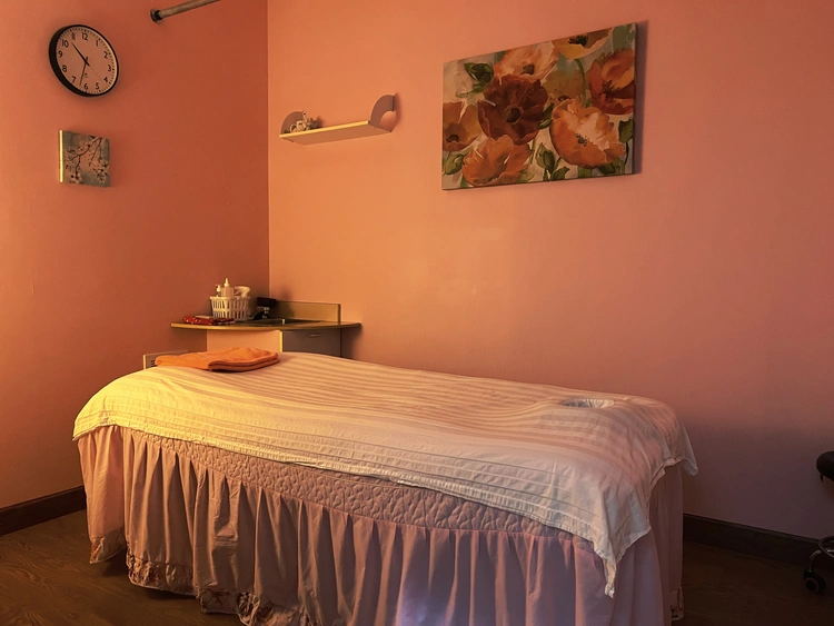 Treatment room featuring warm lighting and massage table setup